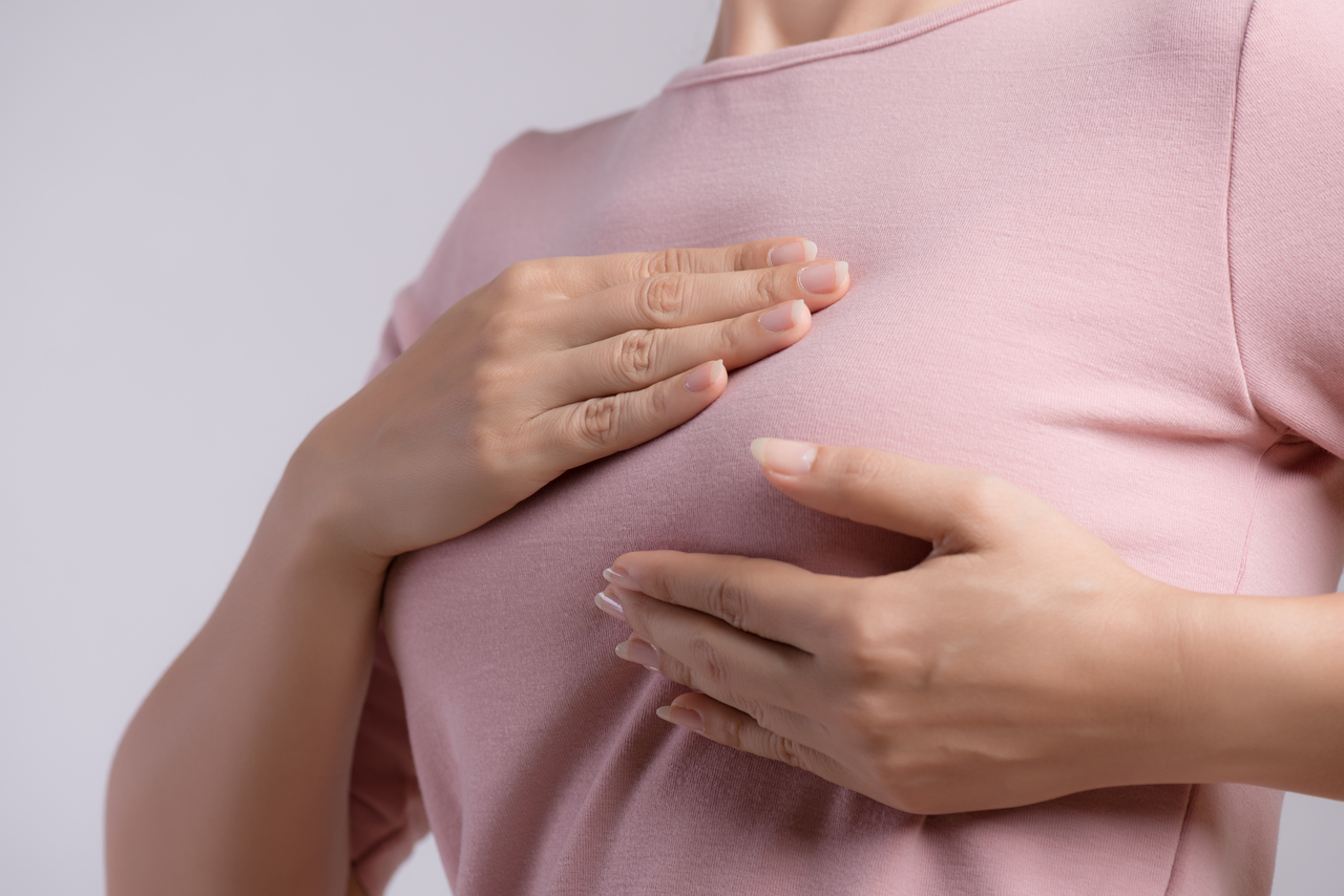 A woman checking a lump on her breast