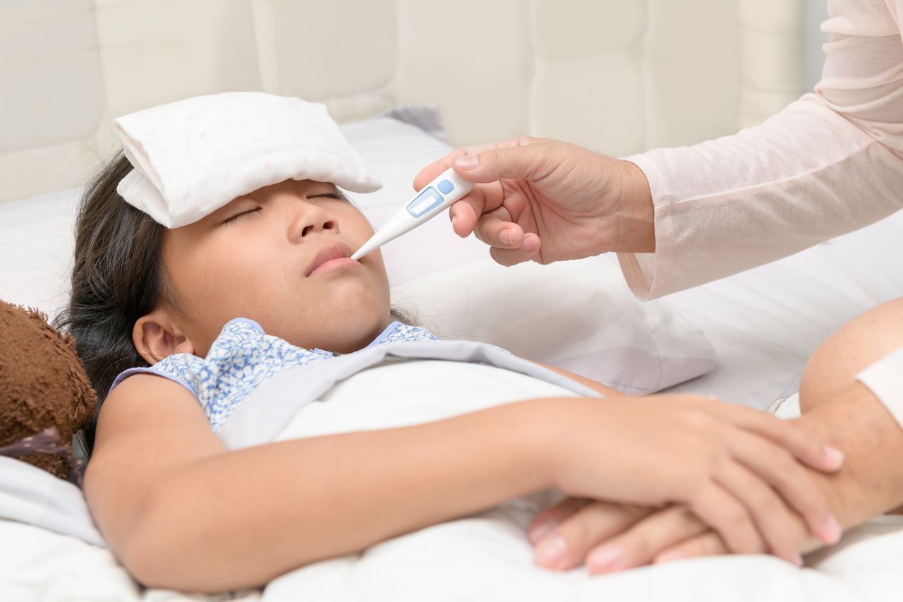 A mother checking her daughter with fever's temperature