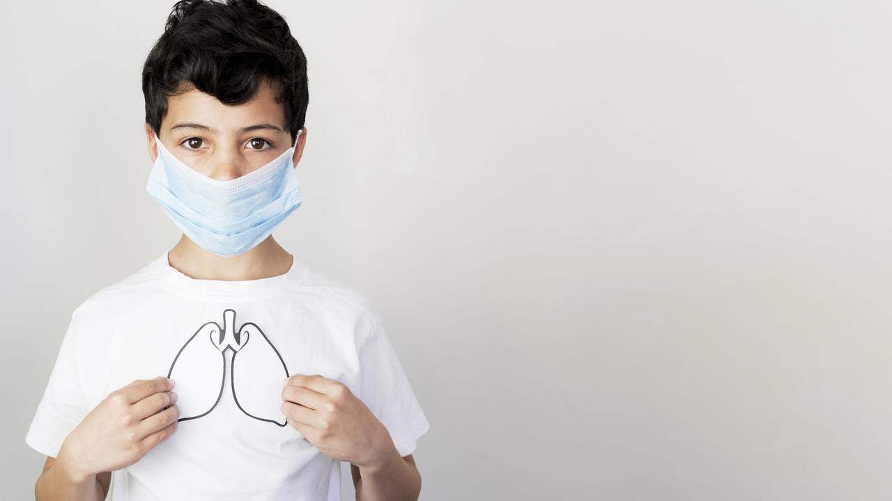 A boy in a face mask showing the effect of COVID-19 on the lungs