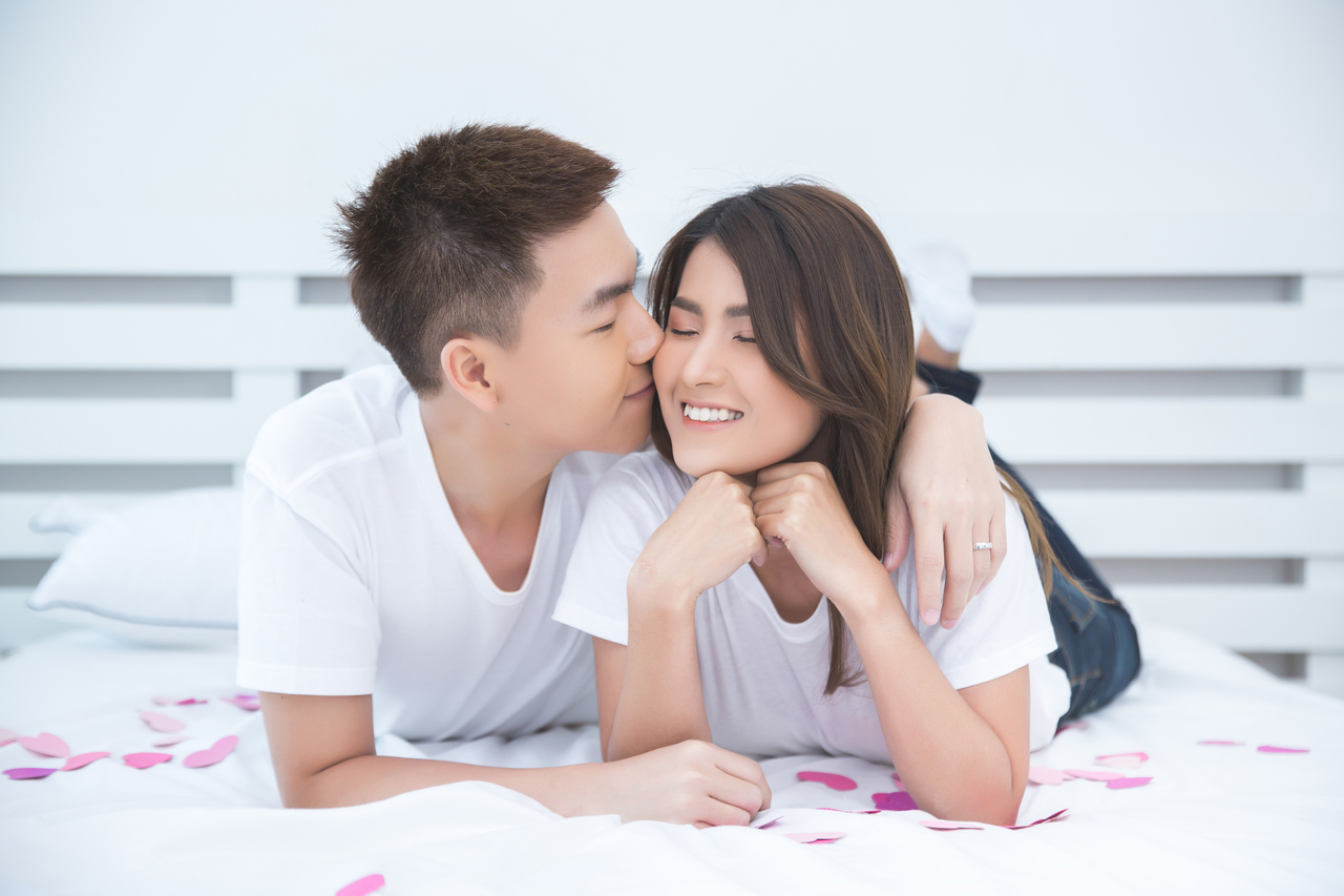 A happy Asian couple in bed