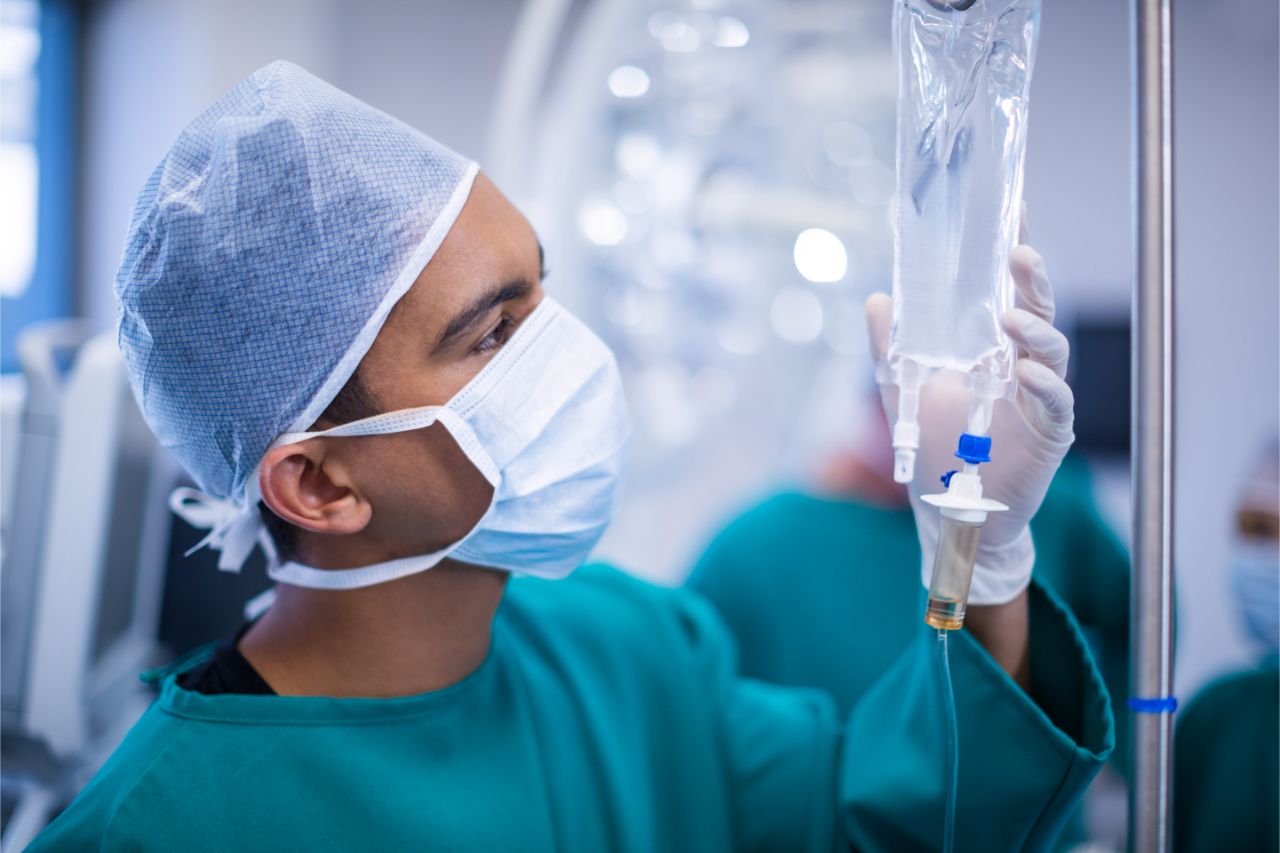 Adoctor fixing an IV drip for a patient